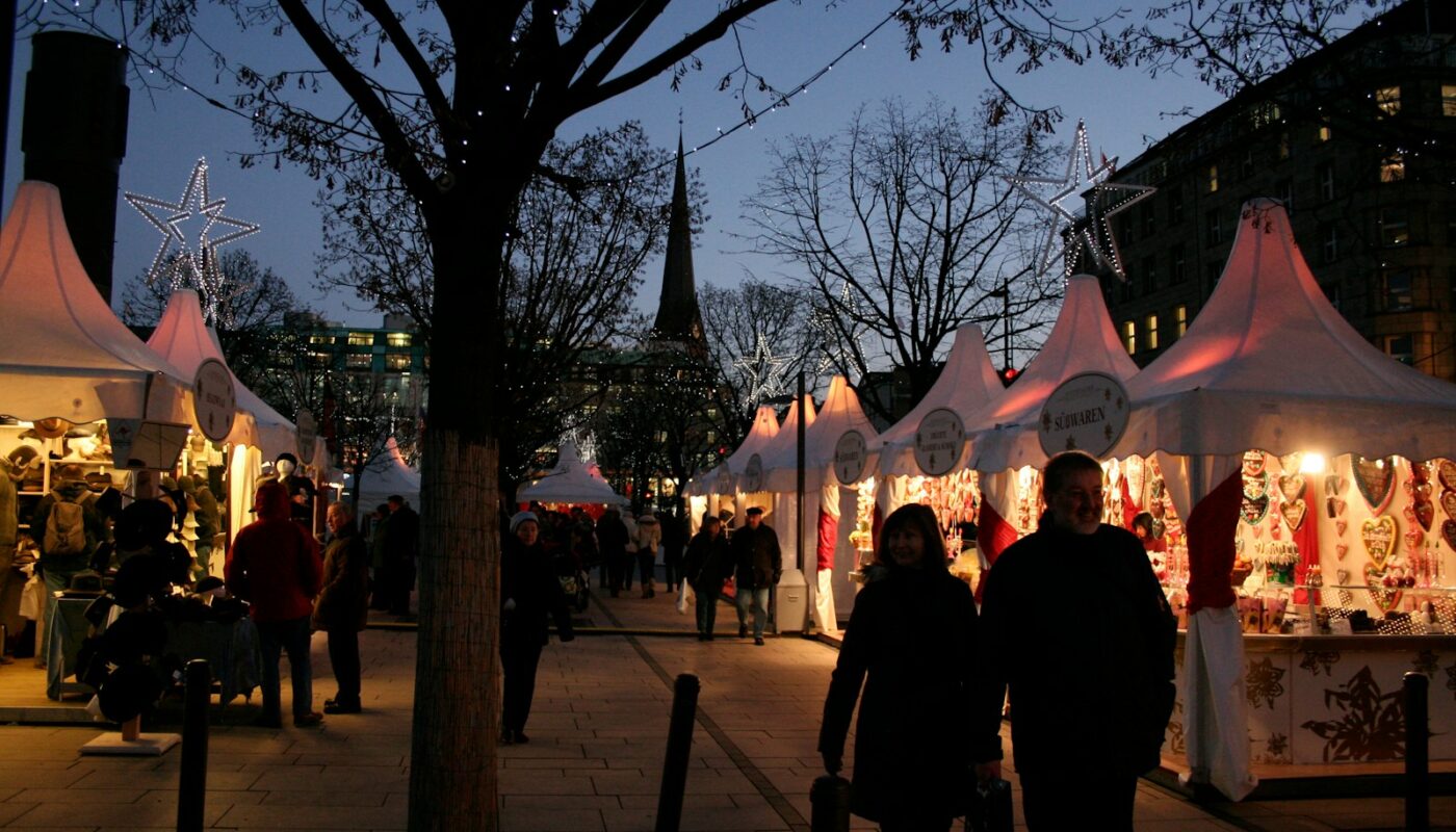 A group of people walking down a street next to tents